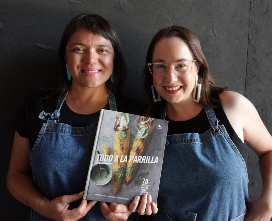 Carolina Carriel e Isidora Díaz sosteniendo el libro Todo a la Parrilla
